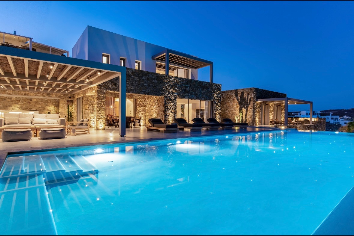 Mykonos villa with illuminated pool at dusk