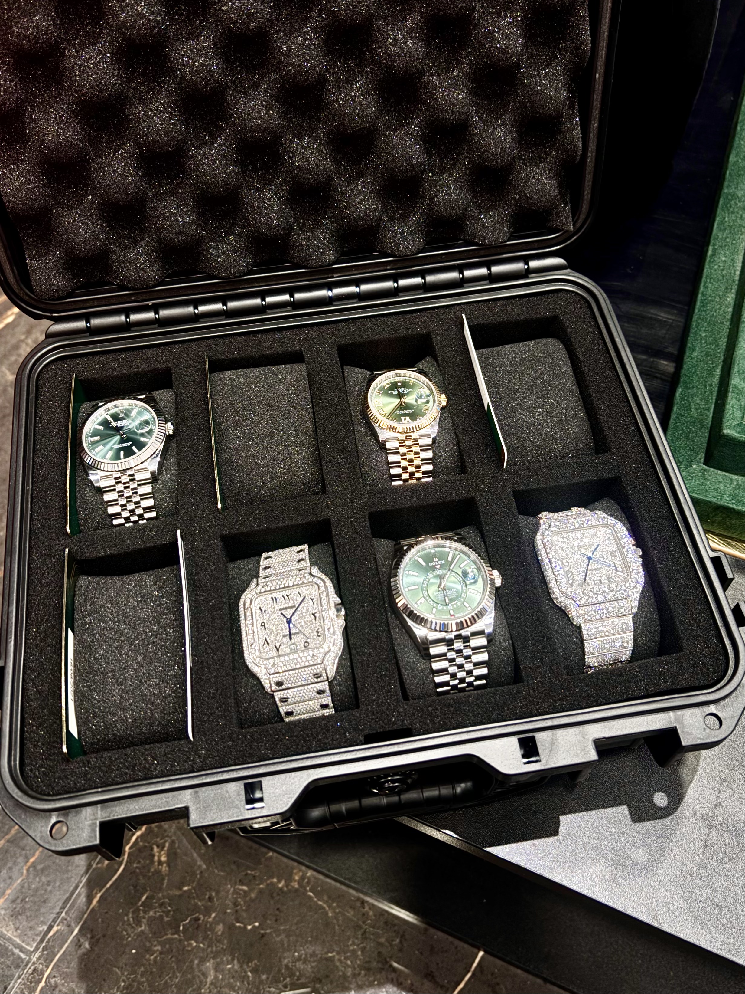 Rolex and iced-out watches in a travel case